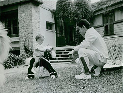 Mini tahta ata binen bir yürümeye başlayan çocukla Yves Saint-Martin'in vintage fotoğrafı.